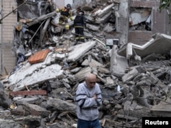 Местный житель ждет, что спасатели найдут под завалами его мать после российского авиаудара. Константиновка, 8 мая 2025 года