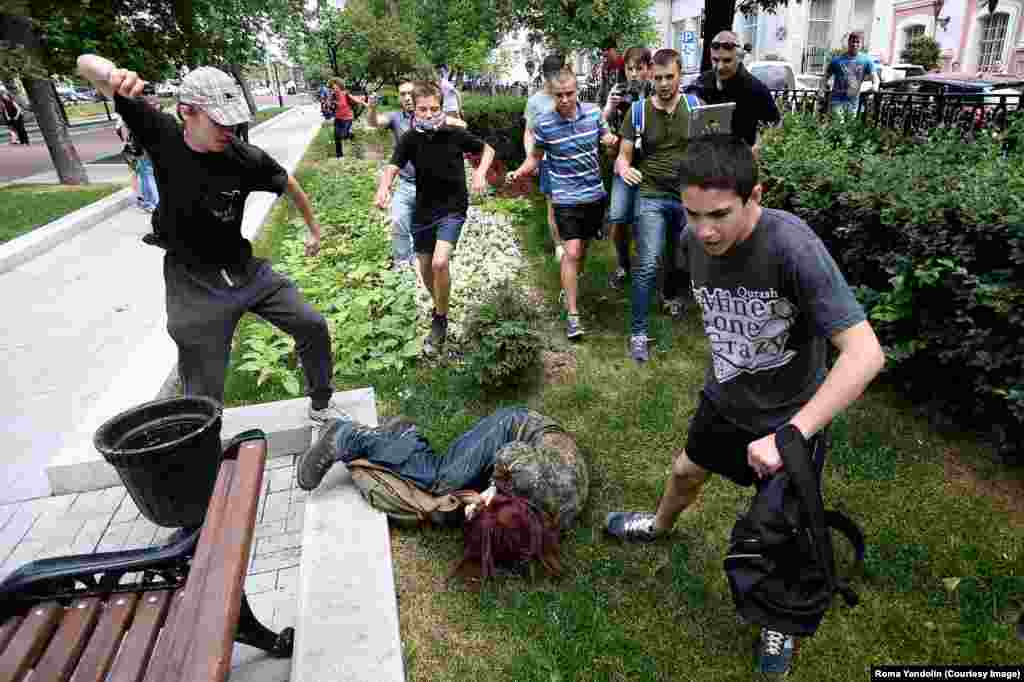 Another participant in the protest against the "gay propaganda" ban being attacked by youths in Moscow. Despite Putin's public statements, activists say the law he signed prohibiting the spread of gay "propaganda" among minors has encouraged discrimination and violence. Putin has also been criticized for bolstering the careers of homophobic public figures. 