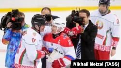 Президент Беларуси Александр Лукашенко, президент России Владимир Путин (слева направо на первом плане) и сын президента Беларуси Николай Лукашенко (справа на третьем плане) по окончании игры в хоккей в ледовой арене "Шайба" (архив)