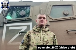 Российский военный из 200-й бригады записывает обращение к родным на фоне такого же бронеавтомобиля "Спартак", что приехал на станцию Озерище под Минском. Скриншот из видео, выложенного в телеграм-канале "Гвардейская 200-я бригада ЛенВО"