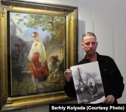 Сергій Коляда тримає одну зі своїх робіт на тлі картини ХІХ сторіччя авторства Тараса Шевченка. На обох роботах зображена Катерина
