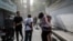 Iran -- People run along a street amid smoke following the Israeli strikes on Iran