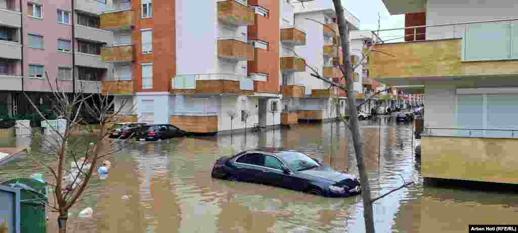 Një veturë e mbuluar pothuajse nga uji shihet pranë një kompleksi banesor në Komunën e Fushë Kosovës. 
