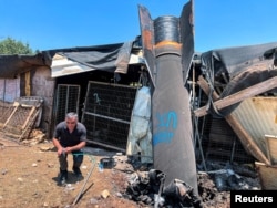 A man poses next to the apparent remains of an Iranian ballistic missile in northern Israel in June.