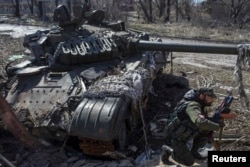 Бойовик біля згорілого українськорго танка, 16 березня 2015 року