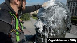 Рабочий в Петербурге моет статую Ленина
