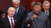 Russian President Vladimir Putin speaks with Chinese leader Xi Jinping before a military parade in Beijing’s Tiananmen Square on September 3.