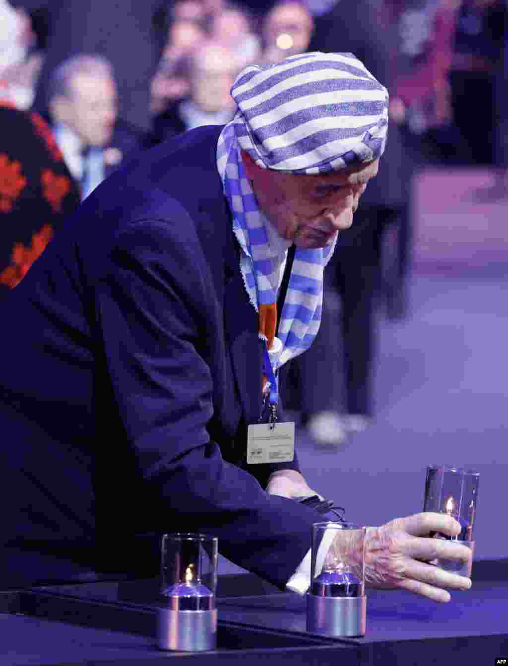 Preživjeli holokausta Stanislav Zalevski polaže svijeću tokom komemoracije na 80. obljetnicu oslobađanja njemačkog nacističkog koncentracijskog logora. 