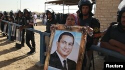 Egipćanka sa slikom Hosnija Mubaraka ispred policijske akademije u kojem mu je suđeno za odgovornost za smrt demonstranata, 2. jun 2012.