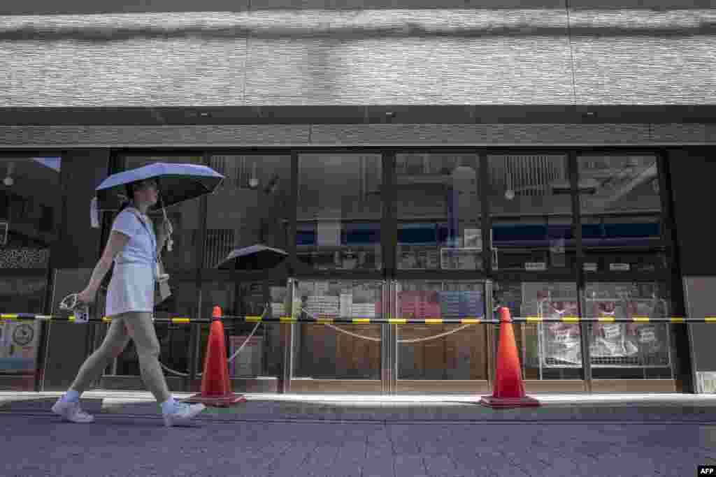 Djevojka prolazi pored zatvorene prodavnice u Fudžisavi, prefektura Kanagava, Japan, 30. jula 2025.