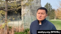 Kosai Makhanbayev in front of the remains of the presidential residence building. October 29, 2025.