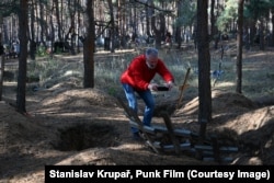 Иво фотографирует могилы в Изюме