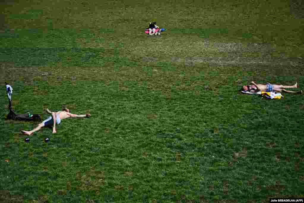 Njerëz duke u rrezuar në diell në parkun publik La Villete, në Paris, më 29 qershor.