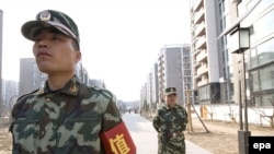 Security guards patrol Beijing's new Olympic Village