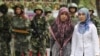 Ujguri su manjina većinom islamske vjeroispovijesti i žive u pokrajini Xinjiang, na sjeverozapadu Kine. (Foto: Ujgurske žene prolaze pored kineskih policajaca u ujgurskom okrugu grada Urumqi u kineskoj regiji Xinjiang, fotoarhiv)