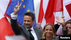 Primarul Varșoviei, Rafal Trzaskowski, candidatul pro-european la președinția Poloniei, în timpul unei întâlniri electorale în orașul Plock pe 11 mai, alături de soția lui, Malgorzata. 