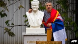 Čovjek pozira pored nadgrobnog spomenika pokojnom Slobodanu Miloševiću, optuženiku za ratne zločine pred Haškim tribunalom i bivšem predsedniku Srbije, Požarevac, Srbija, mart, 2016.