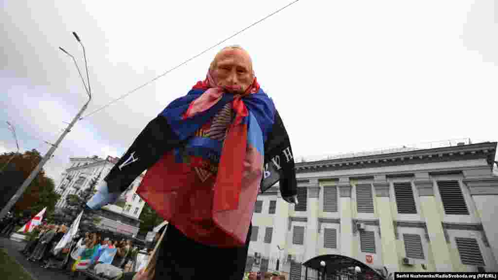 Участники акции у посольства России принесли с собой и сожгли чучело в маске российского президента, завернутое во флаги самопровозглашенных "ДНР" и "ЛНР"