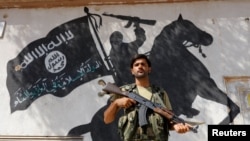 Borac Slobodne sirijske vojske ispred grafita Islamske države u Džarablusu