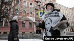 Активист прокремлевского движения раздает листовки в поддержку политики президента Путина