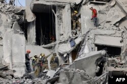 Echipele de urgență verifică ruinele unei clădiri distruse de un atac iranian cu rachete în Bersheeba. 24 iunie 2025.