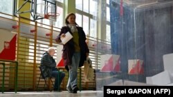 În imagine, alegătoare din Polonia, la o secție de vot din capitala Varșovia, duminică, 18 mai.