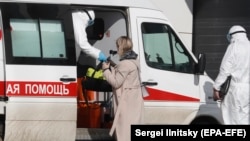 Rusija – Specijalisti u zaštitnim odijelim sprovode pacijente u bolnički kompleks Komunarka u Novoj Moskvi, 16. mart. 