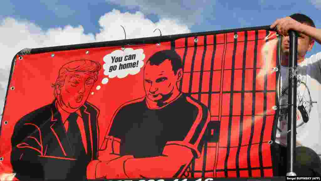 Активіст на масовій акції у столиці України встановлює банер із зображенням президента США Дональда Трампа, який каже Олегу Сенцову: «Ви можете піти додому!» Київ, 13 липня 2018 року. БІЛЬШЕ СВІТЛИН У ФОТОГАЛЕРЕЇ
