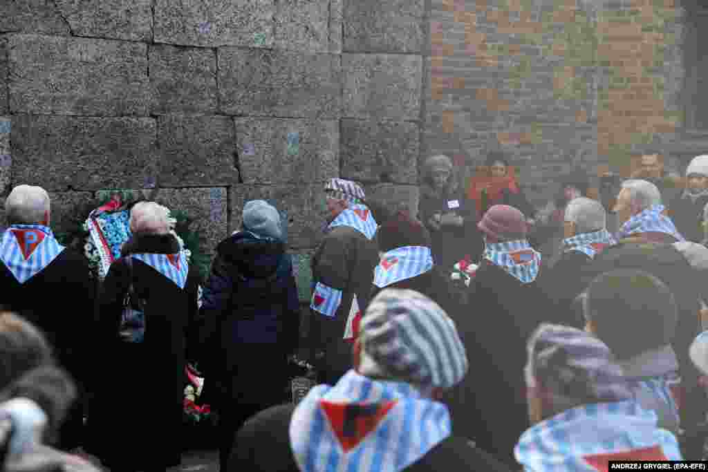 Бывшие узники лагеря возлагают венок к Стене смерти. Здесь расстреливали заключенных. Стена между двумя бараками, в которых было слышно все. 27 января 2020 года 