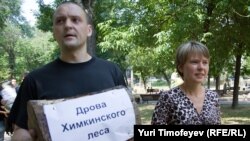 Сергей Удальцов (слева) и Евгения Чирикова с дровами Химкинского леса на акции в Москве, 22 июля 2010