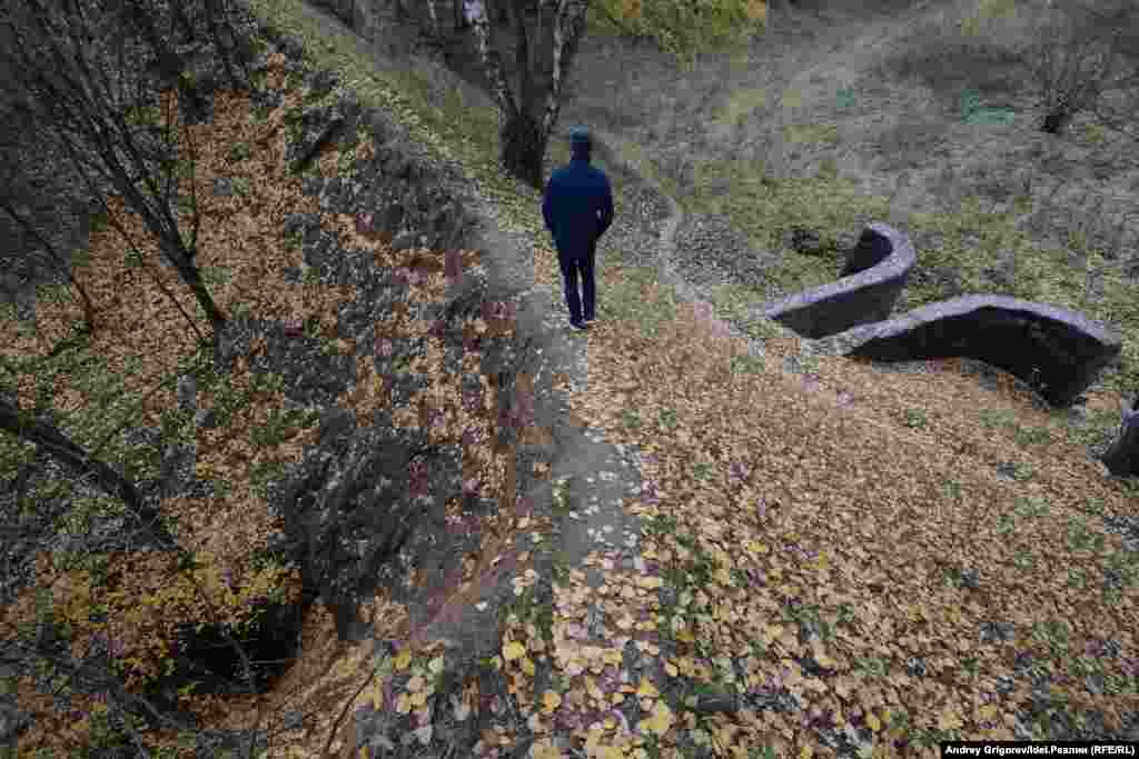 С узкой тропинки насыпи открывается вид на тоннель. 