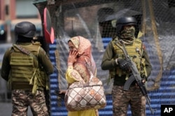 Indijski vojnici stražare dok žena šeta pijacom u Srinagaru, dijelu Kašmira pod kontrolom Indije, srijeda, 7. maj 2025.