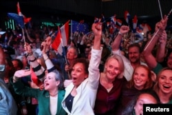 Suporterii D66 reacționând la primele exit poll-uri, la Leida, miercuri seară.