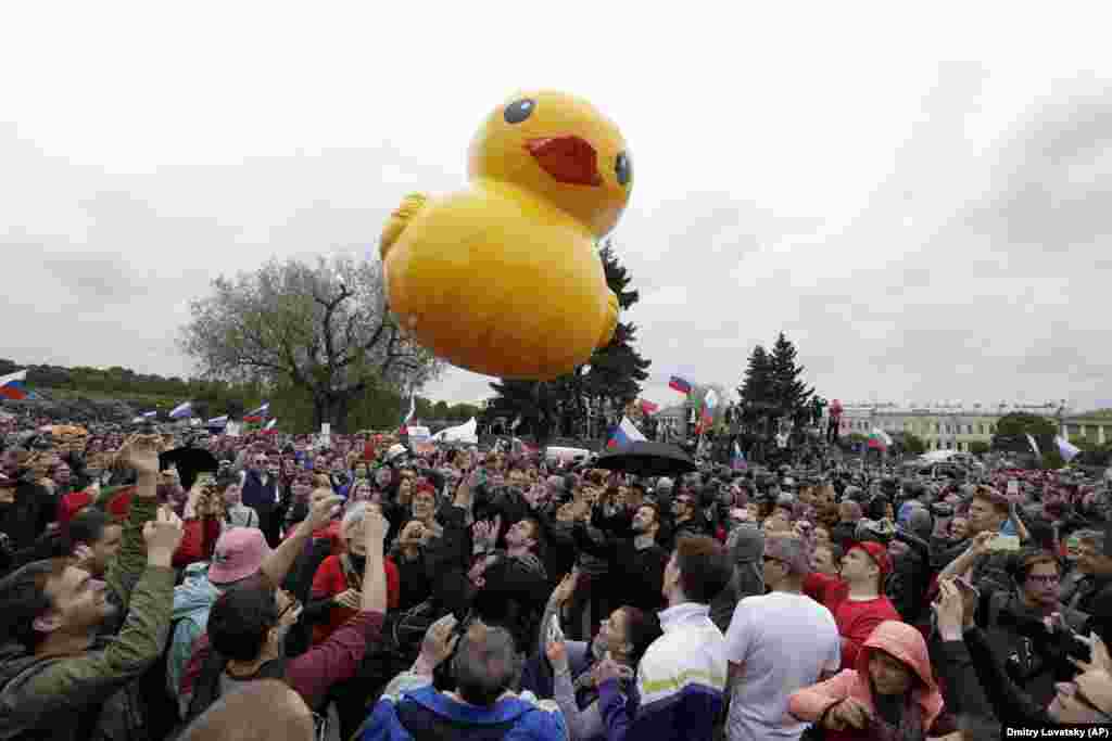 Ljudi se igraju sa igračkom patkom, prihvaćenom kao simbol za navodno Medvedevo bogatstvo tokom okupljanja protiv korupcije u Sankt Peterburgu 12. juna, 2017. godine. Medvedev je postao meta antikorupcijskih protesta nakon videa koji je objavio vođa opozicije Aleksej Navalni, u kojem se vide njegove ekstravagantne nekretnine sa heliodromima, skijaškim stazama i kućama za patke. 