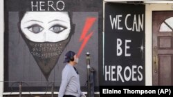 Prolaznik pored zatvorene radnje u Seattleu, SAD, april, 2020.