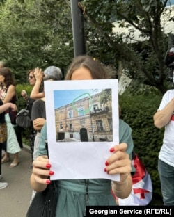 აქციის მონაწილე ავარიული შენობის ფოტოთი - თბილისში ოფიციალური მონაცემებით 10 000-მდე ავარიული შენობაა.