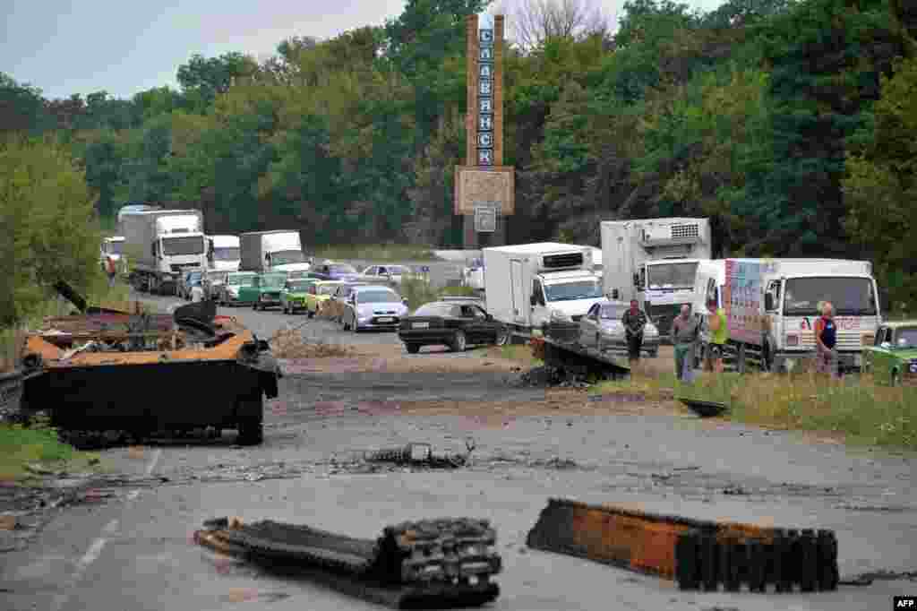 Черга на КПП під Слов'янськом. На передньому плані - залишки бронетехніки бойовиків. 18 липня 2014 року