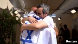 Один из освобожденных израильских заложников Омри Миран обнимает своего отца. Израиль, 13 октября 2025 года.