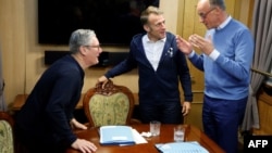 Britanski premijer Keir Starmer (lijevo) i francuski predsjednik Emmanuel Macron (desno) slušaju njemačkog kancelara Friedricha Merza tokom trilateralnog sastanka u vozu za Kijev, 9. maj 2025.