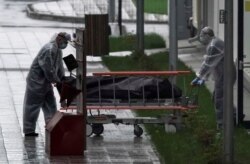 Medicinsko osoblje u Moskvi u zaštitnoj opremi gura preminulog od COVID-19