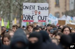 Prosvjednici drže plakat koji prikazuje francusku premijerku Elisabeth Borne i francuskog predsjednika Emmanuela Macrona na kojem piše "svi smo na Borne Outu", tokom skupa u Strasbourgu, istočna Francuska, u četvrtak, 23. marta 2023.