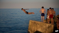 Adolescenți pe malul mării la Barcelona, duminică, 29 iunie 2025.