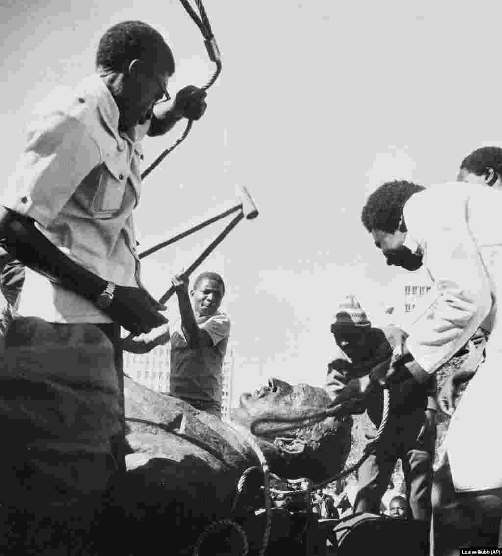 Muškarci udaraju statuu britanskog političara Cecila Rhodesa u Zimbabveu nakon što je afrička zemlja, ranije poznata kao Rodezija, stekla neovisnost od Velike Britanije 1980. godine.