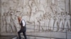 Muškarac prolazi pored bareljefa koji prikazuje fašističkog vođu Benita Mussolinija u naselju EUR poznatom po fašističkoj arhitekturi, u Rimu, Italija, 19. oktobar 2022. (Ilustrativna fotografija)