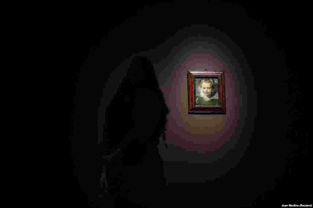 Жінка розглядає картину Рубенса «Портрет Клари Серени Рубенс», 1618 рік.