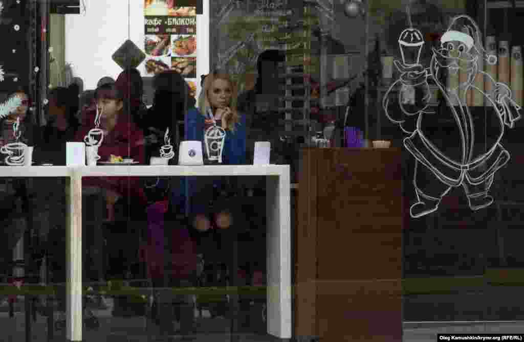 Несколько кафе продолжили работу, но посетители сидят без освещения и в тишине.