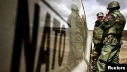 Vojnici iz BiH pored automobila NATO snaga na poligonu u Glamoču, BiH,