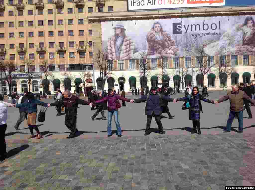 Под песню "Вставай, страна огромная, вставай на смертный бой" люди берутся за руки и образуют цепочку типа "ручейка" 