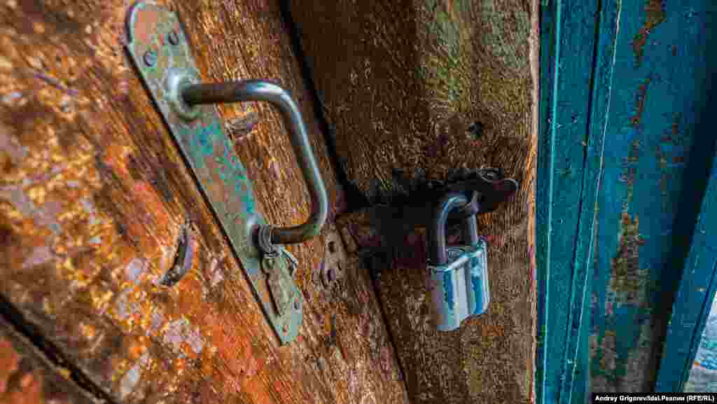 Деревянная дверь и амбарный замок на двери. Двадцать первый век! 