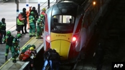 Полициски службеници и службите за итни случаи ги пребаруваат шините под возот LNER Azuma на станицата Хантингдон во источна Англија, 1 ноември 2025 година